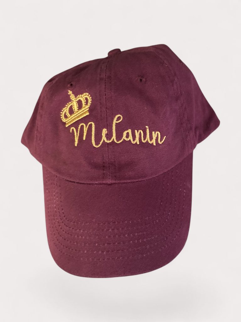 Maroon hat embroidered with crown and the word Melanin