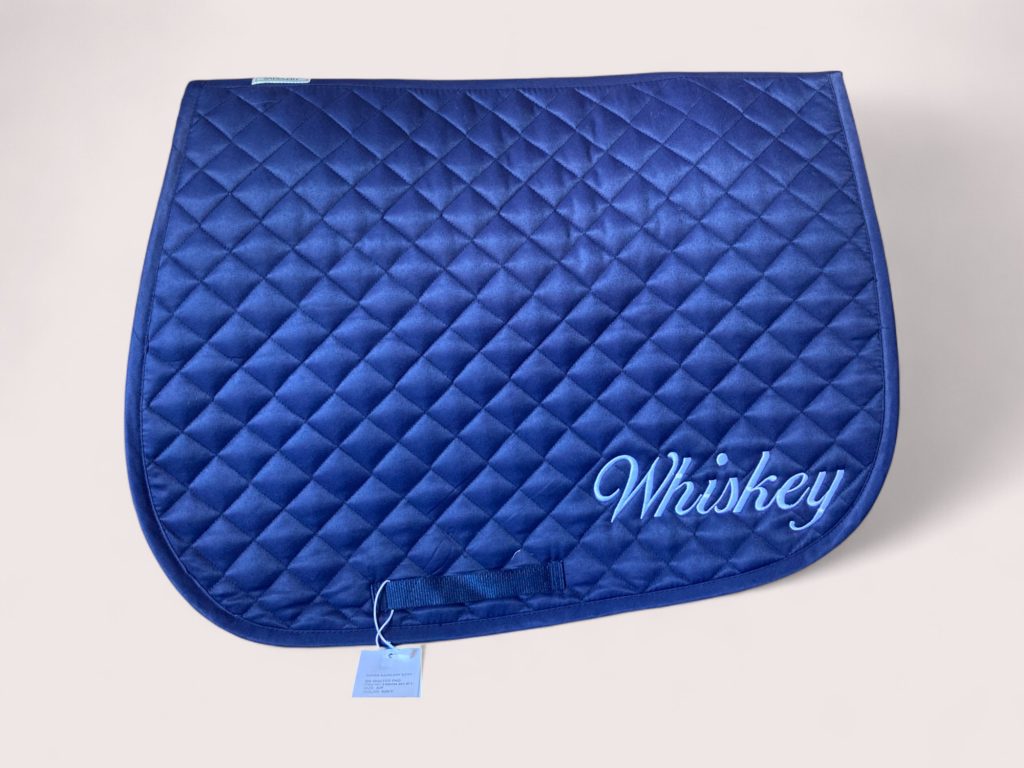 Blue quilted horse saddle pad embroidered with Whiskey